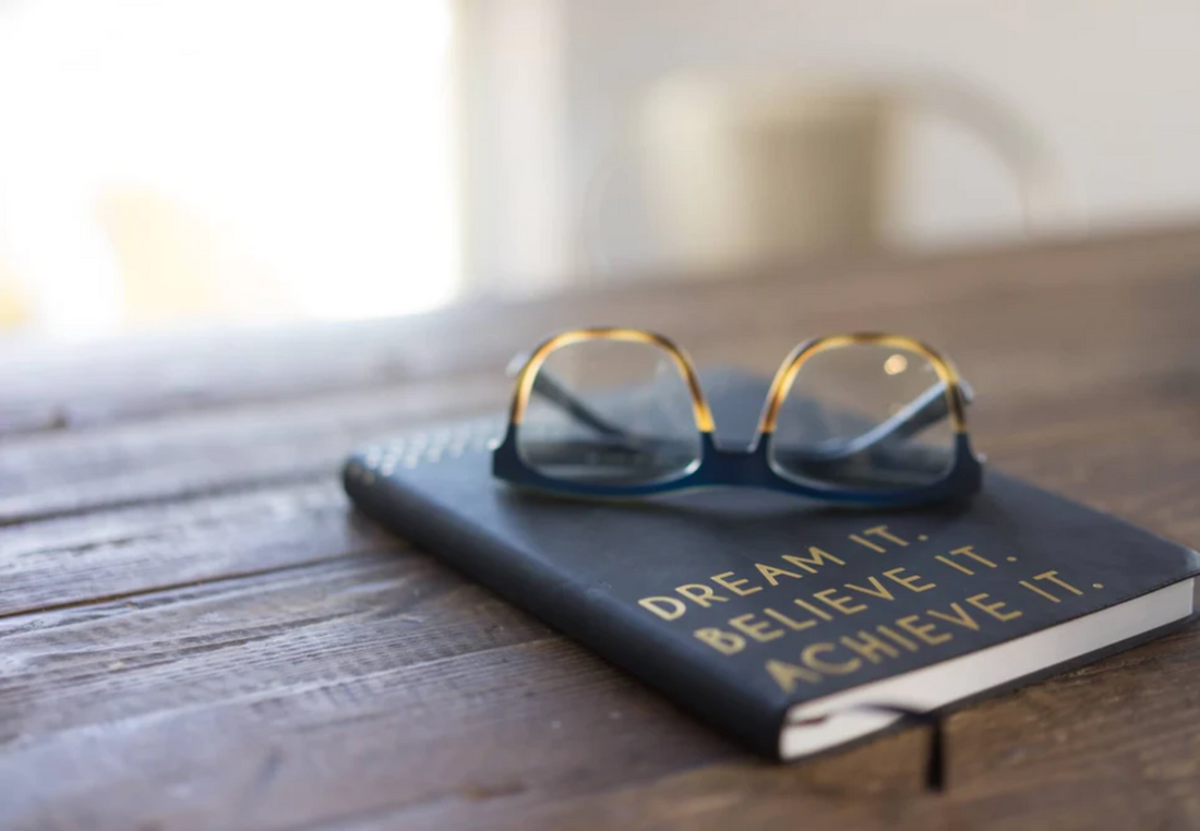 A single eyeglass placed atop a closed book