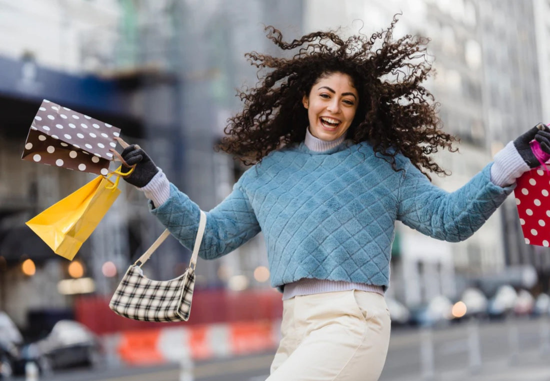 Happy woman jumping with shopping bags